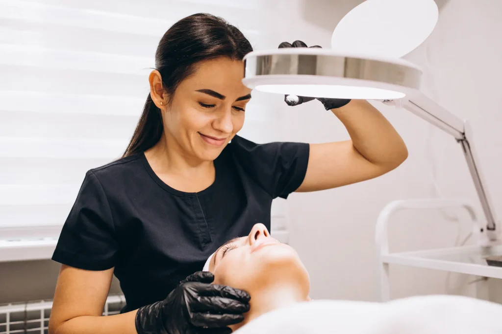 Aesthetician holding light on clients face