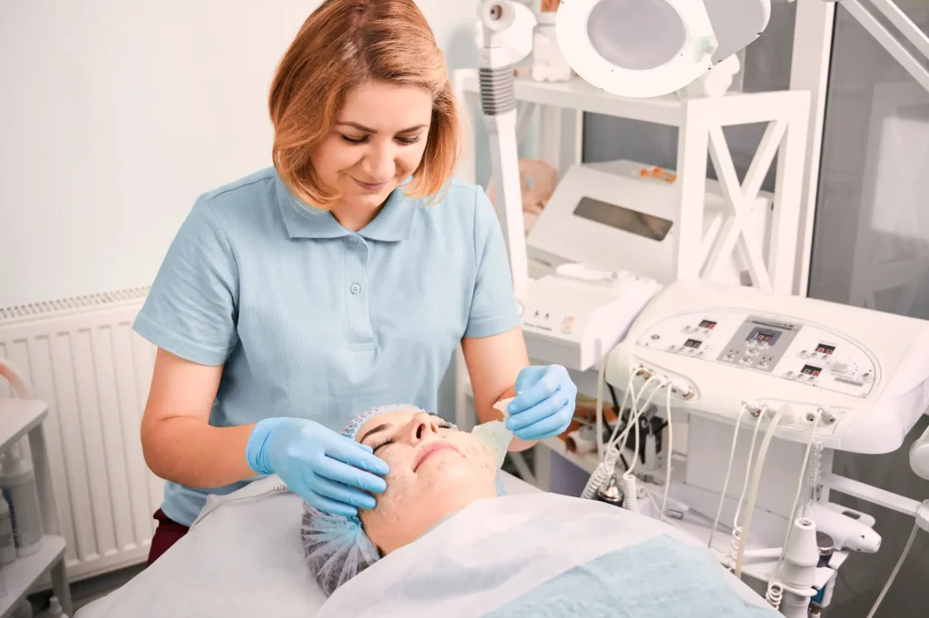 Medical Aesthetician cleaning clients face